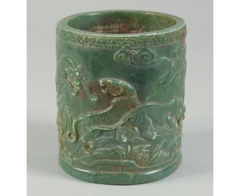 A CHINESE CARVED JADE CIRCULAR BRUSH POT carved with figures. 4.5ins high.