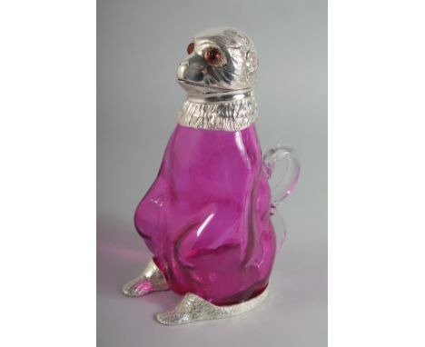 A SILVER PLATED RUBY GLASS CLARET JUG with glass eyes.