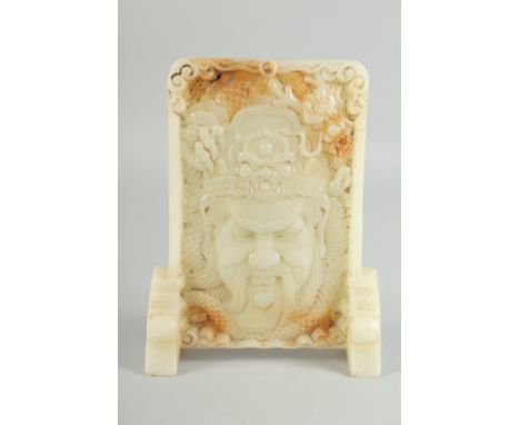 A CARVED CHINESE WHITE JADE SCREEN carved with a head. 9ins high.