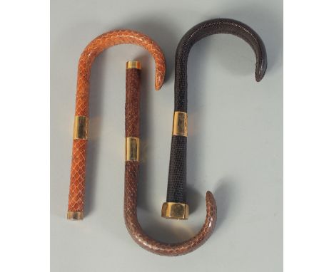 THREE SNAKESKIN COVERED WALKING STICK HANDLES. (3).