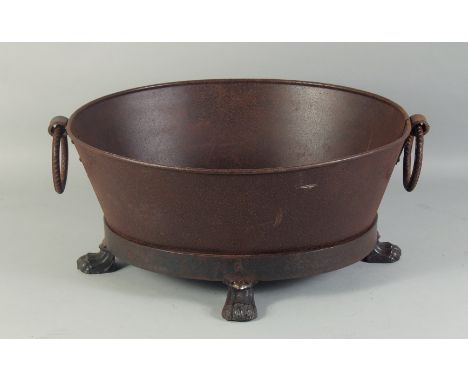 AN IRON CIRCULAR PLANTER with ring handles on claw feet. 1ft 8ins long.