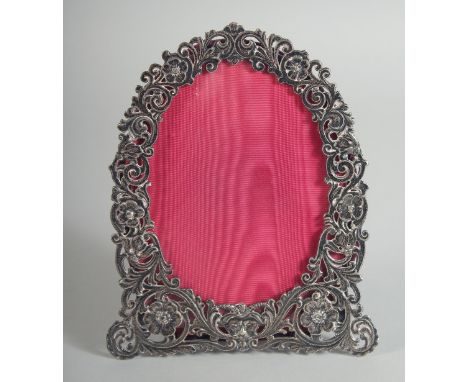 A VICTORIAN PIERCED SILVER EASEL PHOTOGRAPH FRAME with scrolls and flowers. 7ins x 5.5ins.