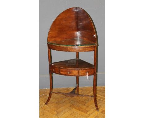 An early 19th century mahogany corner washstand, the raised upstand over shelf concealing provision for basin, above a single