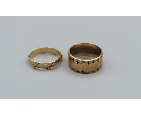 A pair of 9ct decorative band rings, one a thick band with star engraving, the other a wire pattern fine ring. Total approxim