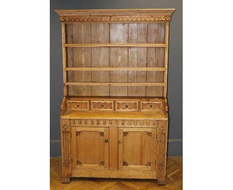 A late 19th/ early 20th century Continental pine tall dresser, the moulded and fret carved cornice over four shelves and four