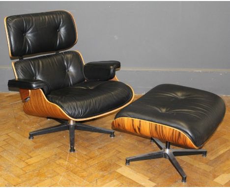 After Charles and Ray Eames, a rosewood veneer shell and button black hide upholstered lounge chair and matching ottoman, eac