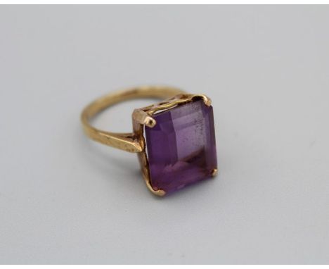 A step cut Amethyst cocktail ring in yellow metal setting stamped 18ct, size O, gross weight approximately 5.8gm