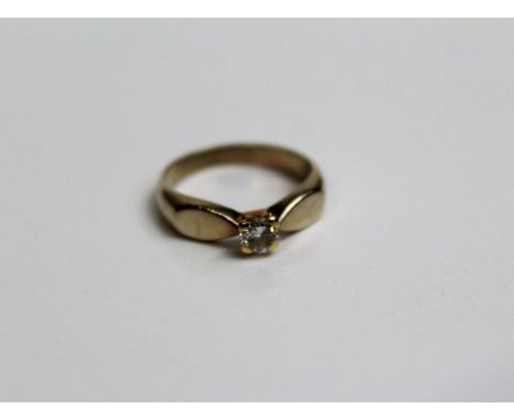 A yellow metal solitaire ring set with a 1/4 ct round brilliant cut diamond. Gross weight approximately 3.5gm (With a certifi
