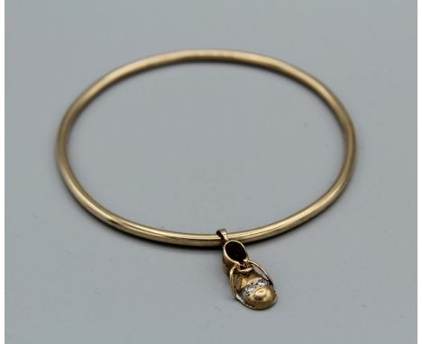 A yellow metal bangle, unmarked, with an unlaced shoe charm, hallmarked 9ct gold, set with two melee diamonds, gross approxim