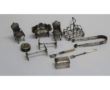 A small quantity of decorative silver and silver mounted items comprising a small toast rack, a pair of knife rests, a pill b