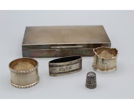 A selection of silver comprising a silver thimble, marked for Chester, two napkin rings (unengraved), a silver wood lined cig