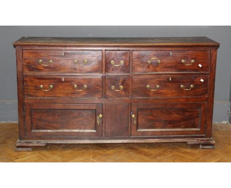 A George III mahogany low dresser, the rectangular top above an arrangement of two short and four long drawers with brass swa