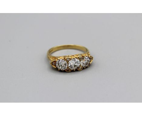 A three stone old European cut diamond dress ring, the central stone with an approximate diameter of 6.5mm, the supporting st