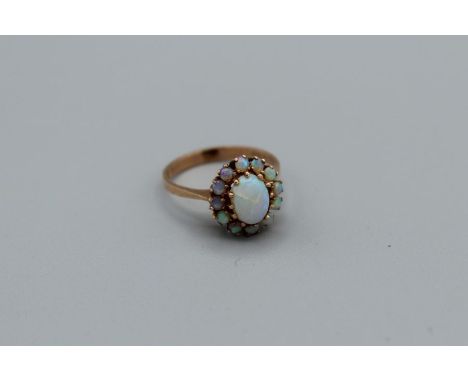 An opal cluster ring in rose yellow metal, size P, unmarked, 2.8gmThe centre opal is crazed