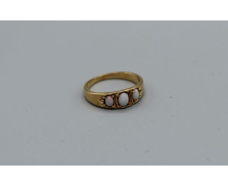 An opal three stone ring in yellow metal, assessed as gold, size N, approximately 3.5gm weight&nbsp;