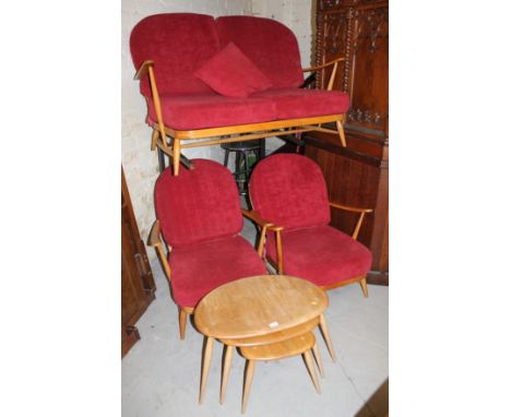 A nest of three Ercol light wood tables, each top of shaped oval form on turned supports, the largest, 38cm high, 64cm wide, 