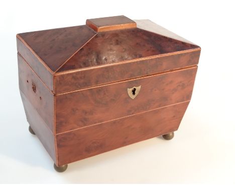 A early 19thC burr walnut tea caddy, of compressed sarcophagus form with a rectangular top, hinging to reveal a plain interio
