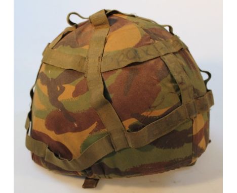 A post war British infantry helmet, with camouflage webbing.