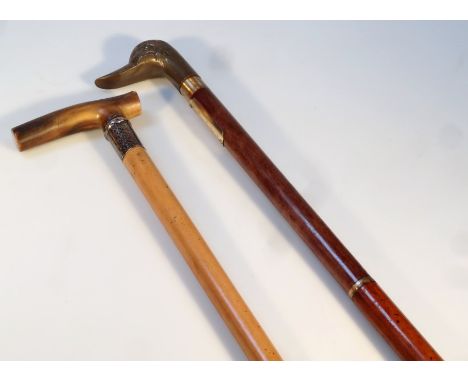 A 20thC walking stick, with brass duck head end and gilt coloured metal collar set with a drinking glass, with rubber end, 94