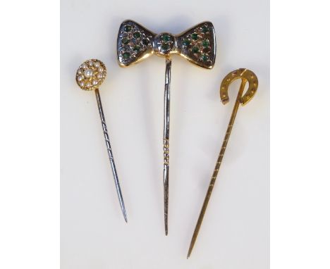 Three various stick pins, to include one set with a bow, 6cm high, horseshoe, and a seed pearl flower, each yellow metal, two