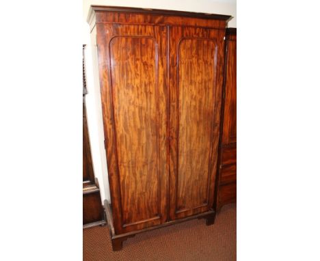 A Victorian mahogany wardrobe, the moulded cornice raised above two fielded panelled doors, revealing a part fitted interior 
