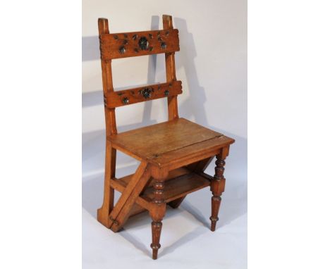 A late 19thC oak metamorphic library step ladder/chair, of hinging articulated form, carved with leaves and scrolls to the ba
