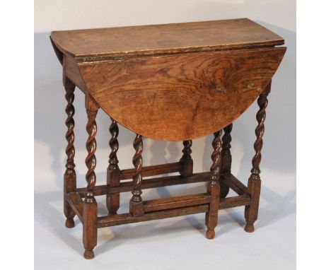 An 18thC and later oak gate leg table, the circular top raised above a single frieze drawer on turned supports, joined by pla