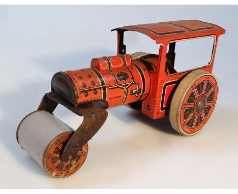 An early 20thC German tin plate steam tractor, with clockwork action, in orange and black with grey front wheel, 12cm high. (