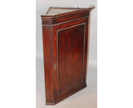 An 18thC oak hanging corner cupboard, the moulded door revealing a fitted interior with three serpentine shelves on a moulded