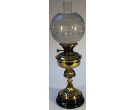 An early 20thC brass oil lamp, with a frosted and etched glass circular shade and plain glass funnel, on a shaped part gadroo