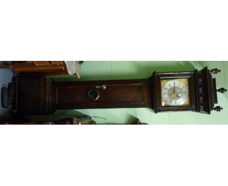 An oak eight day longcase clock, caddied pediment, moulded trunk door with a glazed lenticle, 12-inch brass dial, ringed wind