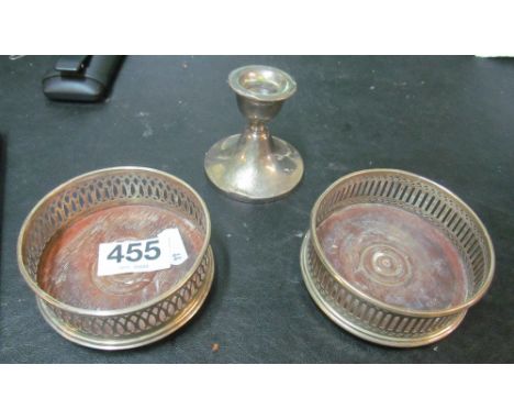 A pair of small silver coasters and a dwarf candlestick