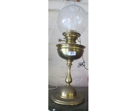 A brass oil lamp with shade and funnel