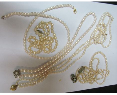 A three strand pearl necklace with clasp marked 585, pearl necklace with flowerhead clasp and three other pearl necklaces