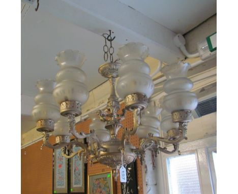 An eight branch metal ceiling light with opaque shades