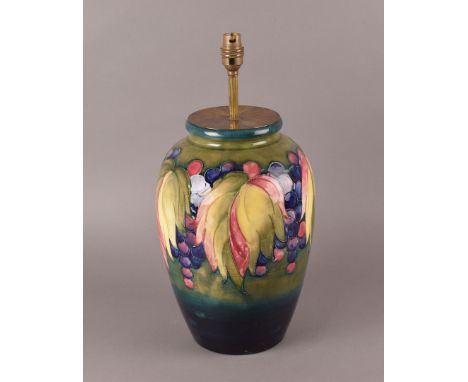 A large 1950s Moorcroft Pottery ovoid lamp base, having green ground decorated with leaves and berries to the shoulders, sign