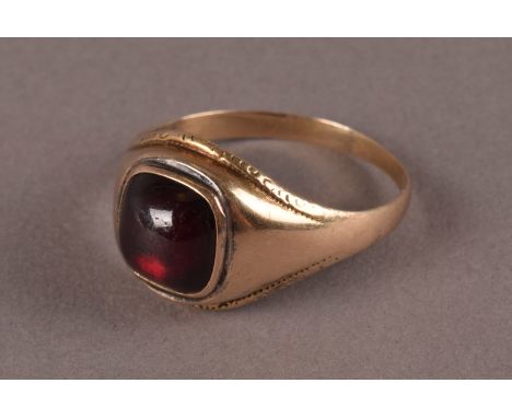 A vintage gold and garnet gentleman’s signet ring, having a cabochon red stone in rubbed over foil back setting, approx 3g an