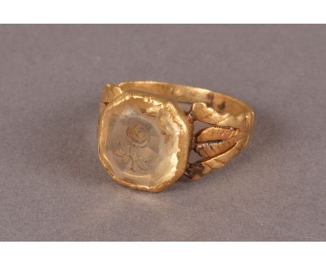 A late Georgian period posy ring, the ornate yellow metal mount with engraved and split shoulders supporting a light yellow h