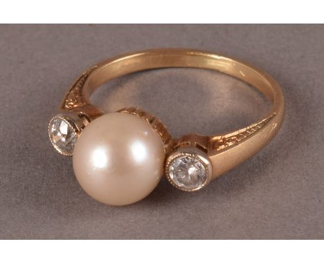 A vintage pearl and diamond dress ring, the white pearl flanked by a pair of diamonds, one a modern brilliant, the other a tr