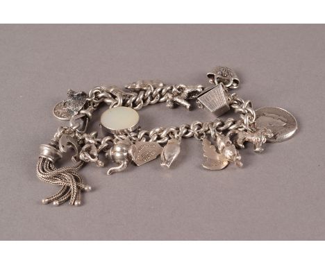 A vintage silver and white metal charm bracelet, the curb link chain supporting mulitple charms, approx 70g 