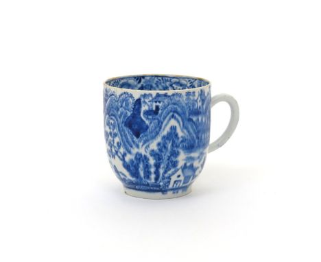 A rare Bow blue and white coffee cup  c.1765-70, painted with a dense landscape pattern of figures and small buildings amidst