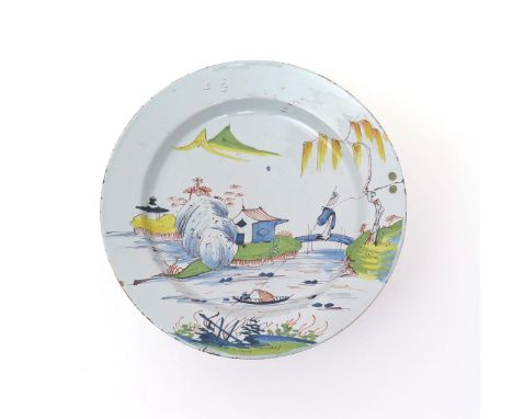 A large delftware polychrome charger  mid 18th century, Liverpool or Bristol, painted in the Chinese style with a figure cros