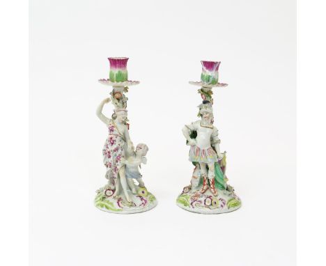 A pair of Derby candlestick figures of Venus and Mars  c.1760, each standing before a stump applied with colourful flowers, r