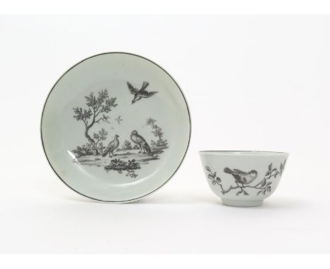 A Worcester teabowl and saucer  c.1760, printed in black with ornithological designs, the teabowl with a finch perched on a b