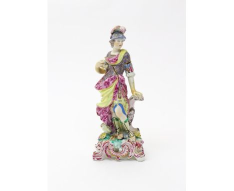 A large Bow figure of Minerva  c.1760, standing on a tall rococo base with puce and gilt highlights, resting one hand on her 