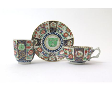A rare Worcester matched armorial trio  c.1768, comprising a teacup, a coffee cup and a saucer, painted with panels of Kakiem