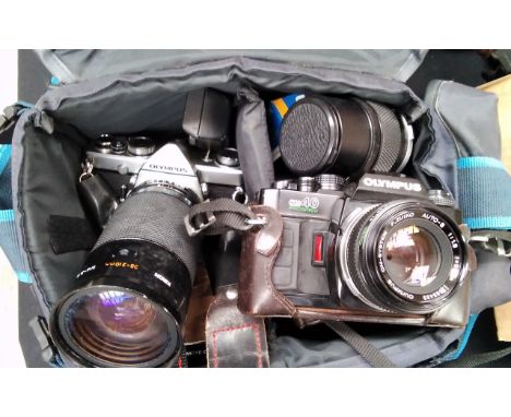 An Olympus OM-1N SLR camera and OM-40 Program, cased with accessories including 135mm lens 