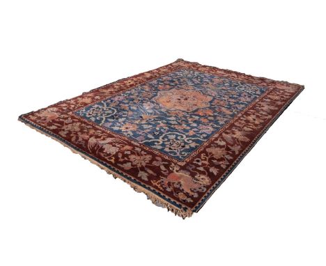 SEMI ANTIQUE HAND WOVEN CARPET with petal shaped centre medallion on a sky blue field and a spandrele and a design of large t