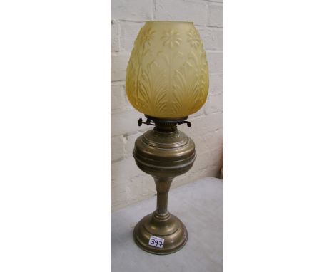 Brass oil lamp with yellow glass shade, no chimney.