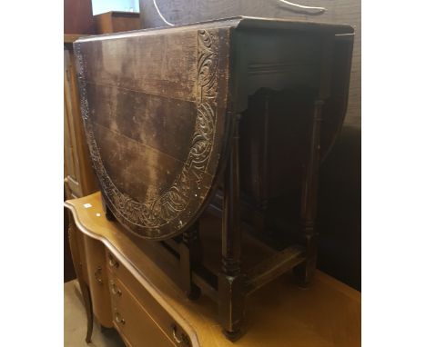 Dark oak drop leaf gate leg table, 1930s with carved border detail. 